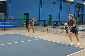 Man and woman playing on Peak Time Pickleball Courts